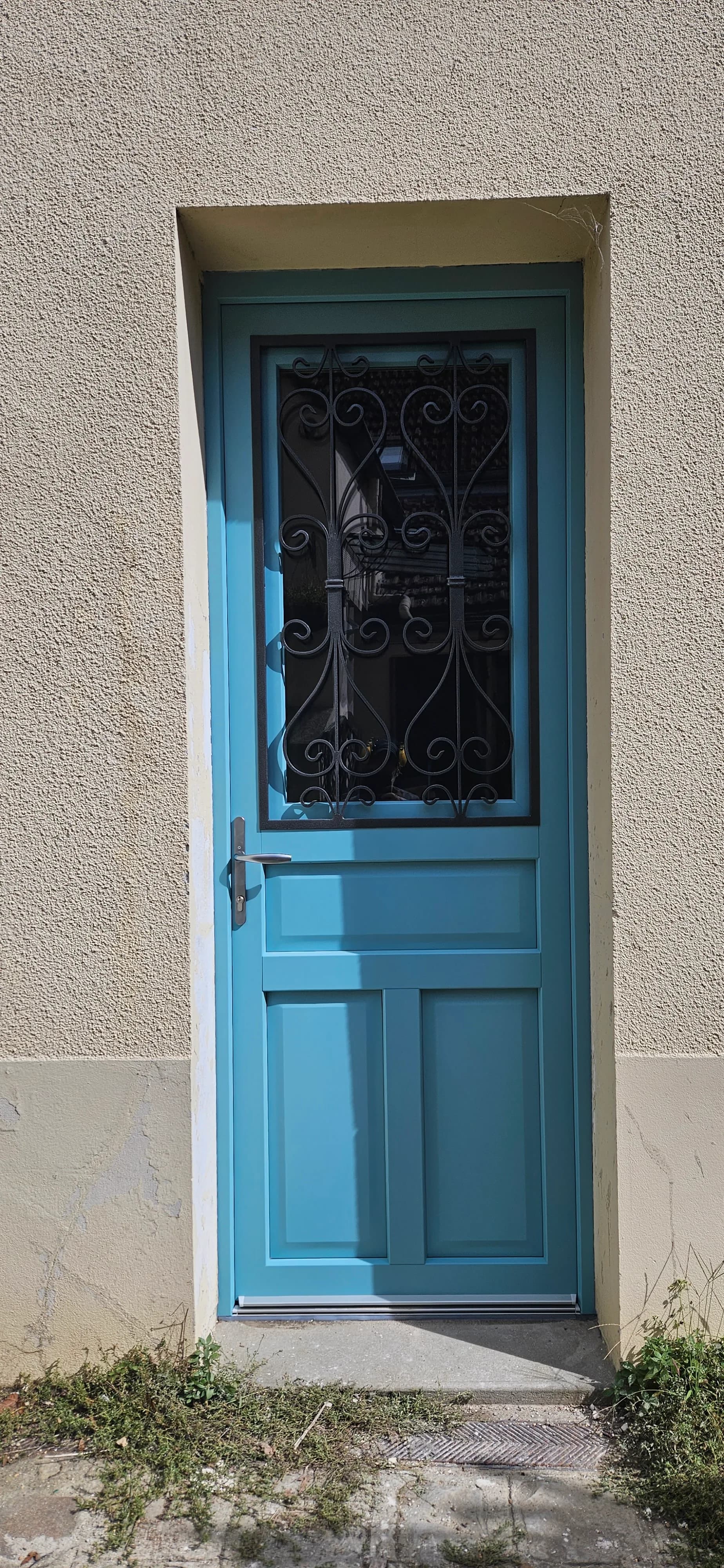 Nouvelle porte d'entrée bleue vitrée avec grille de défense en fer forgé