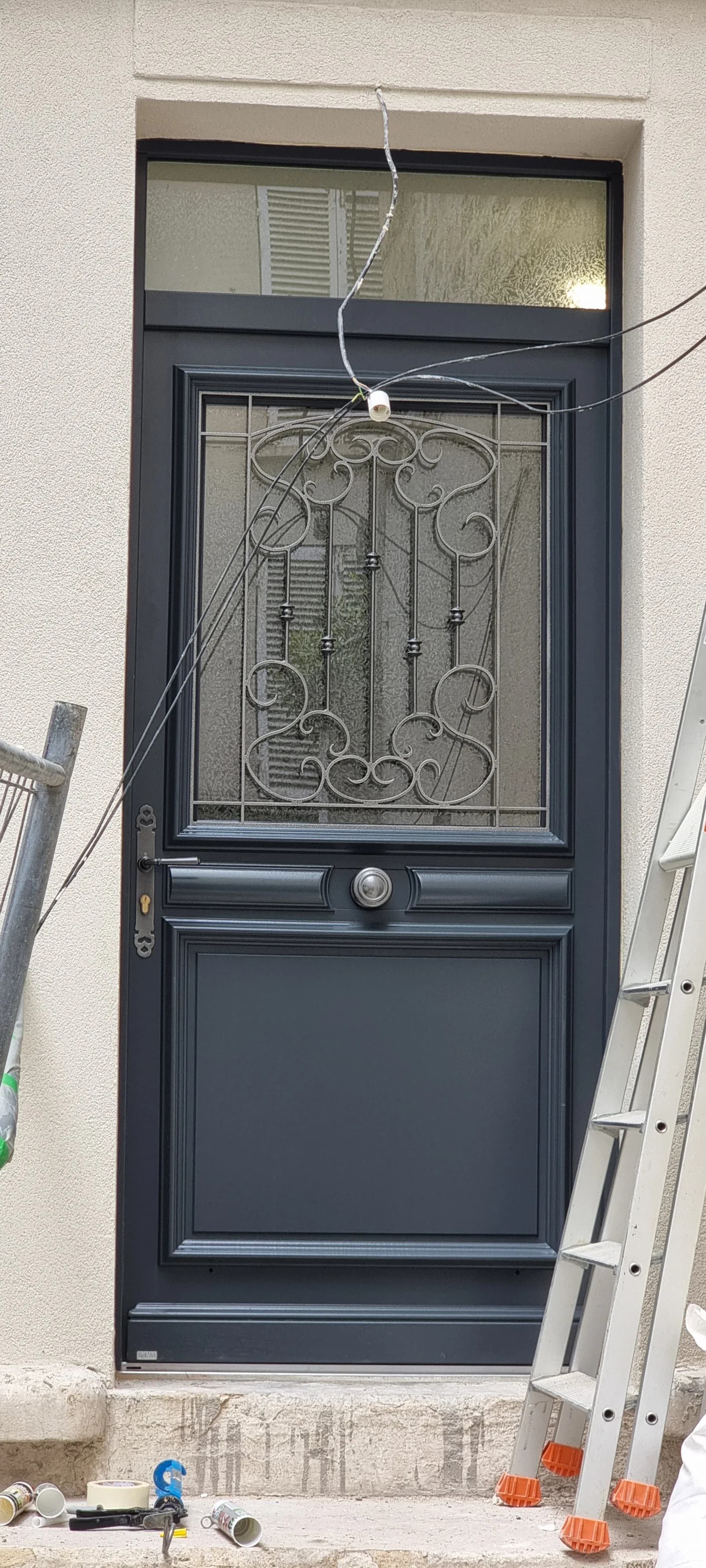 Porte d'entrée gris anthracite avec grille de défense en fer forgé