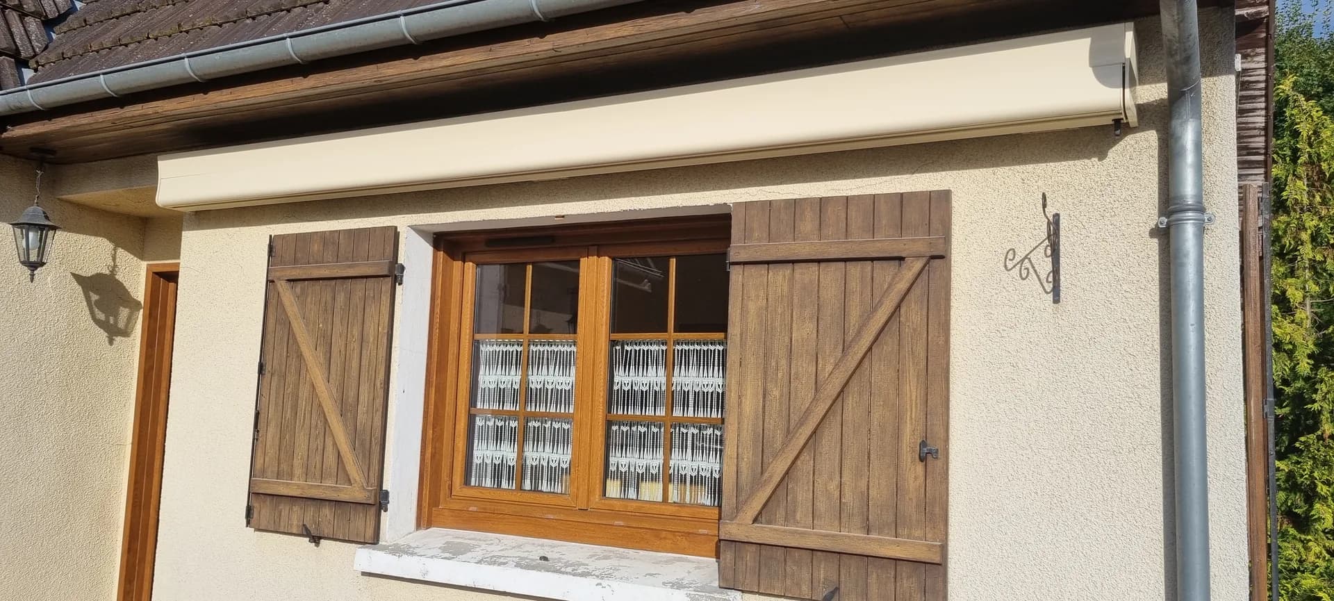 Fenêtre PVC avec volets battants imitation bois, finition soignée